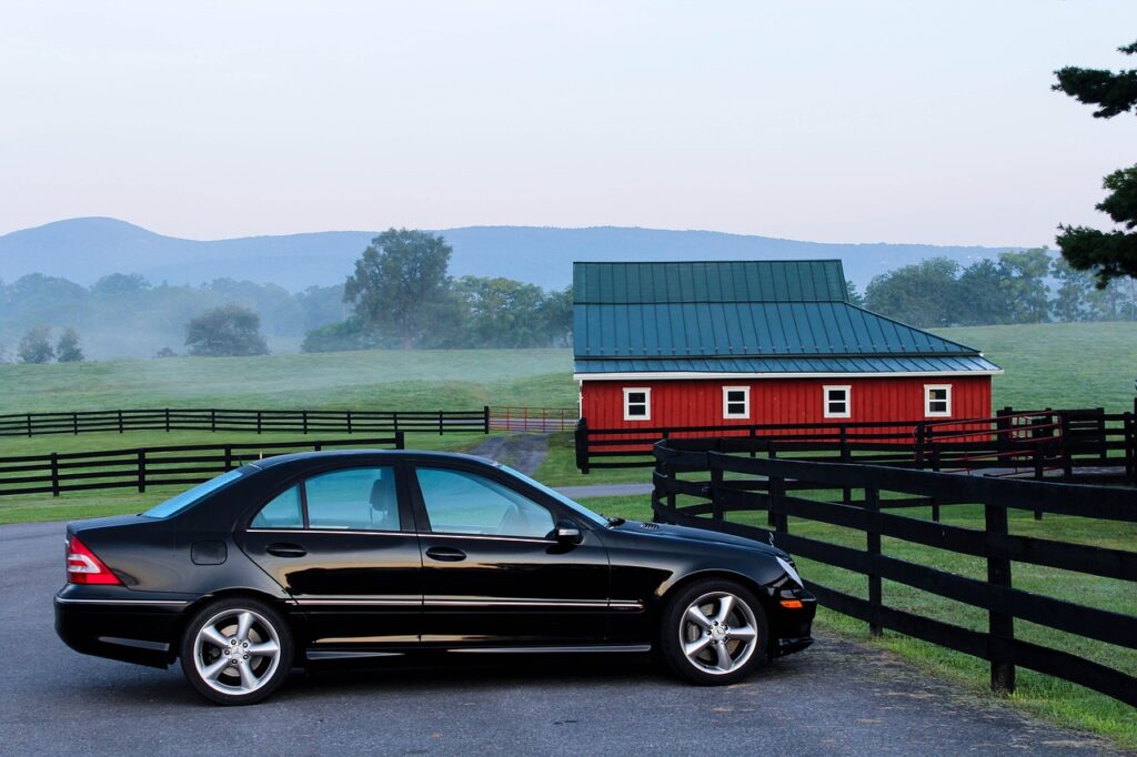 Auto im Sommerhoch mit Haus im Hintergrund